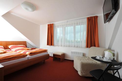 布拉格哈比塔特16号旅馆的卧室配有床、椅子和窗户。