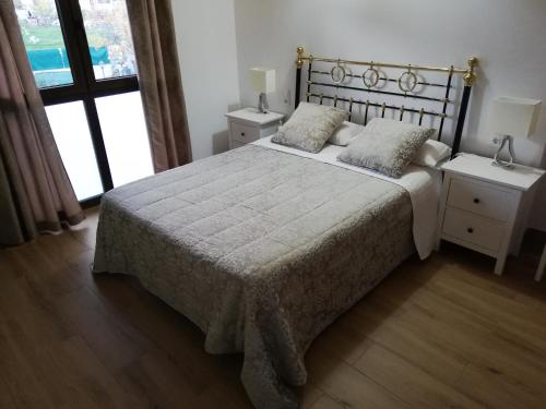洛索亚河畔布伊特拉戈Puente viejo de Buitrago casa Enebro的一间卧室配有一张带两个枕头的床
