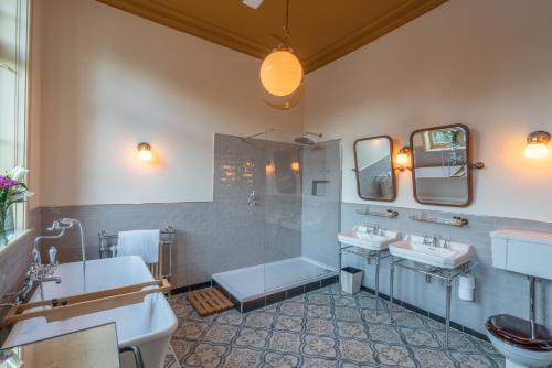 贝德福德Albero Bedrooms的浴室配有2个盥洗盆、淋浴和浴缸。