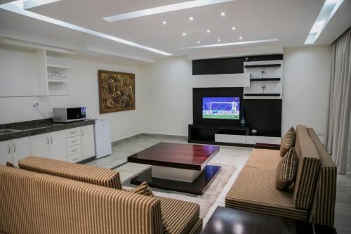 卢萨卡Twangale Resort & Spa的客厅配有两张沙发和一台电视机