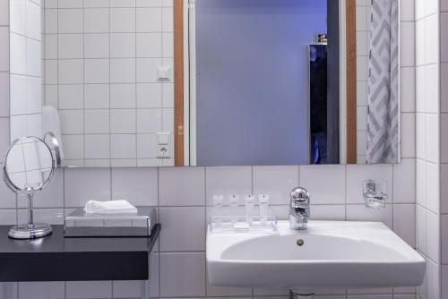 哈诺桑德第一施塔特酒店的白色的浴室设有水槽和镜子