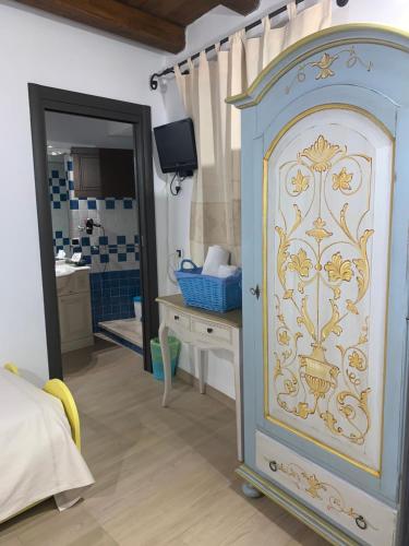 TonaraAntica Potecarìa的卧室配有带镜子的蓝白色橱柜