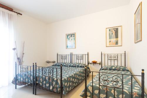 利尼亚诺萨比亚多罗阿尔皮别墅 的卧室设有2张床和白色的墙壁。