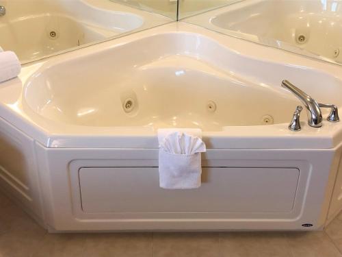 艾恩芒廷艾伦山乡村套房酒店的白色浴缸,上面有毛巾
