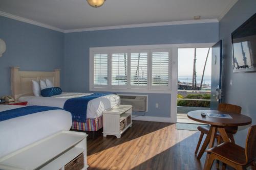 圣克鲁兹海滩街套房酒店的一间卧室设有两张床、一张桌子和一个窗口