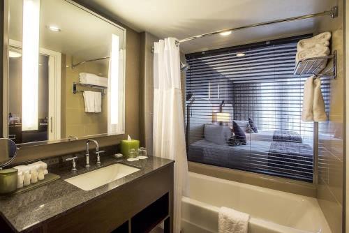 北温哥华顶点码头酒店的一间带水槽和镜子的浴室以及一张床