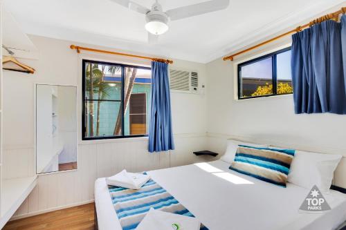 汤斯维尔珊瑚海岸观光假日公园的一间卧室设有两张床和两个窗户。