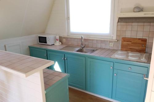 东代恩凯尔克Gezellige chalet in Nieuwpoort - Opkuis al inbegrepen in de prijs的厨房配有蓝色橱柜、水槽和窗户。