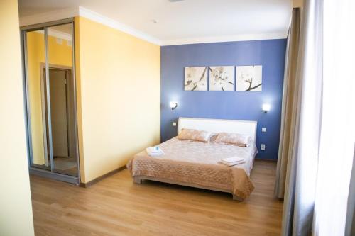 阿克托比Sad Dolgoletiya Hotel的一间卧室设有一张床和蓝色的墙壁