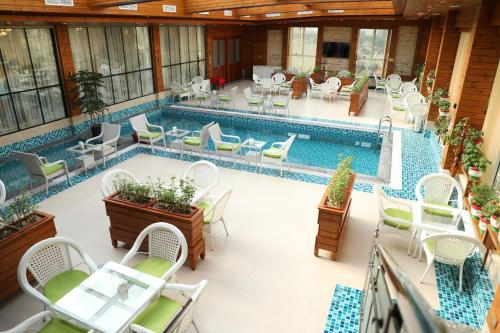 Shīrpūr喀布尔星级餐厅酒店的一个带桌椅的室内游泳池和游泳池