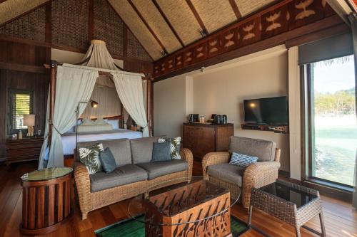 科罗尔The Pristine Villas and Bungalows at Palau Pacific Resort的客厅配有沙发和1张床