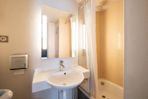 塞克兰B&B HOTEL Lille Seclin的白色的浴室设有水槽和镜子