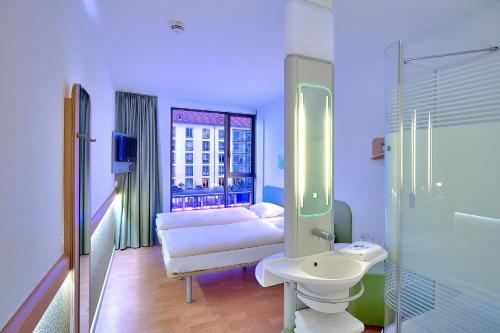 德累斯顿德累斯顿市宜必思快捷酒店的浴室设有床、水槽和镜子