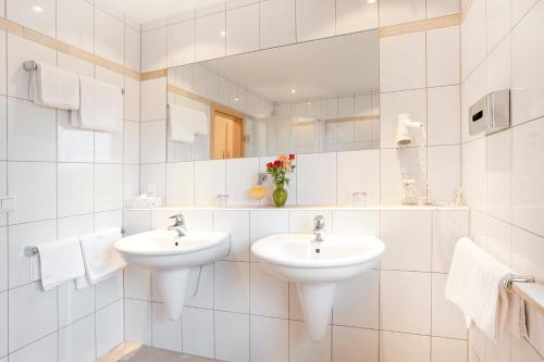 纽伦堡凯弗尔施泰因加尼酒店的白色的浴室设有两个盥洗盆和镜子