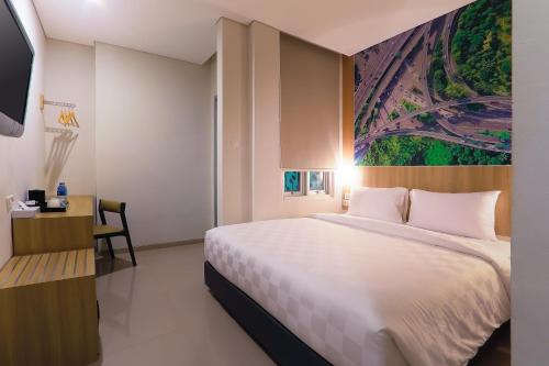 明古鲁省Cordela Inn Bengkulu的卧室配有一张白色大床和一张书桌