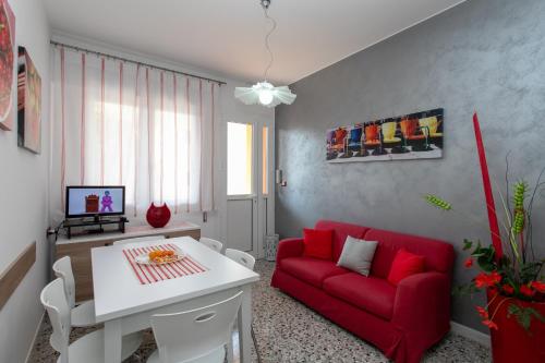 利多迪耶索罗Appartamenti Bedin, JESOLO LIDO的客厅配有红色的沙发和桌子