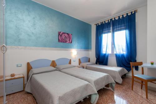 利多迪耶索罗Appartamenti Bedin, JESOLO LIDO的一间卧室设有两张床和窗户。