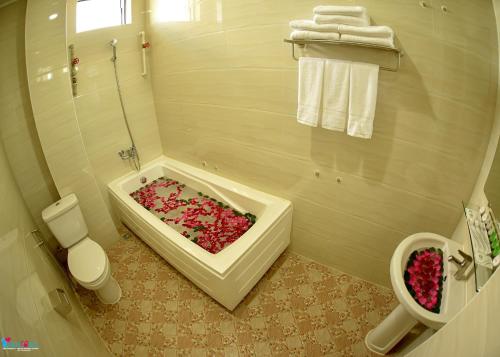 曼德勒Hotel Homey Mandalay的浴室配有装满粉红色花卉的浴缸。