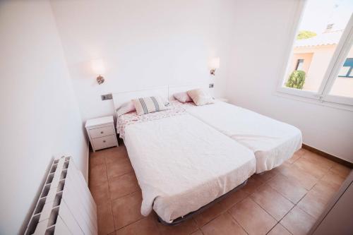 卡莱利亚德帕拉弗鲁赫尔Apartamento reformado a 2 minutos de la playa en Calella!的白色的卧室设有床和窗户