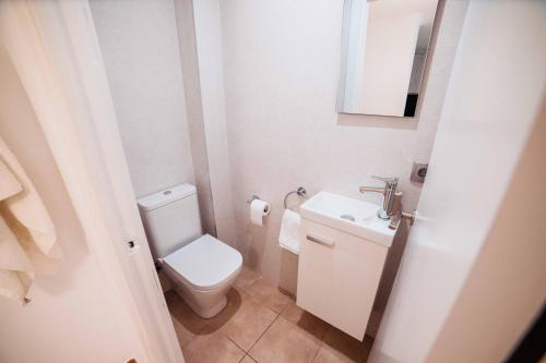 卡莱利亚德帕拉弗鲁赫尔Apartamento reformado a 2 minutos de la playa en Calella!的白色的浴室设有卫生间和水槽。