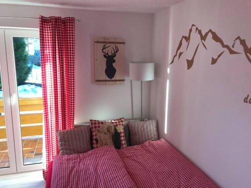 奥伯斯特多夫Almsternchen 2 - Almsternchen 3的卧室配有红色的床,墙上挂着鹿的照片