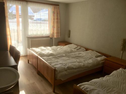 萨斯格伦德B&B Haus Granit Saas Grund的一间卧室设有两张床和窗户。