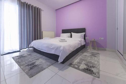 雅典Modern fully-equipped house, 5 min walk from metro的一间卧室配有一张大床,拥有紫色的墙壁和地毯