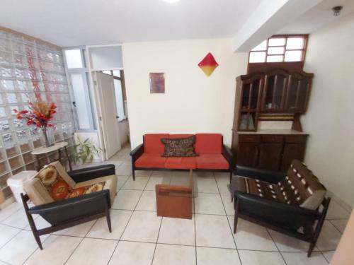 利马塔塔帕利马机场客房公寓的客厅配有椅子和红色沙发