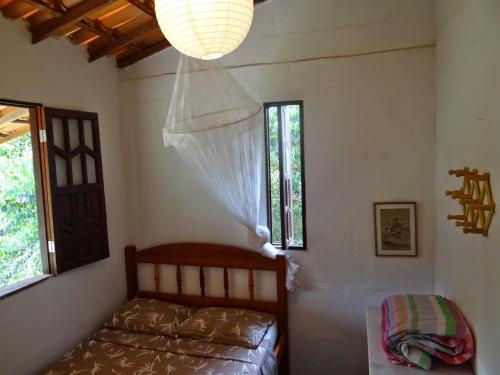 韦尔卡鲍Casa dos Gatos的一间卧室设有一张床、一个窗户和一个吊灯。