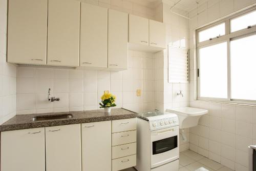 贝洛奥里藏特潘普哈公寓式酒店的白色的厨房配有白色橱柜和水槽