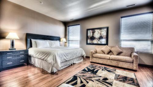 大草原城Grand Inn & Residence- Grande Prairie的一间卧室配有一张床和一张沙发