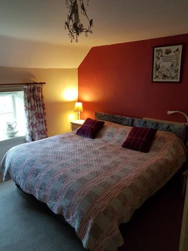 GillamoorManor Farm Bed & Breakfast的一间卧室设有一张红色墙壁的大床