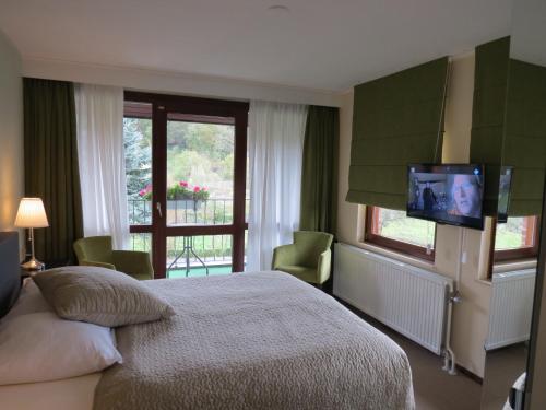 斯莱纳肯斯伦纳肯住宿酒店的卧室配有一张床,墙上配有电视。