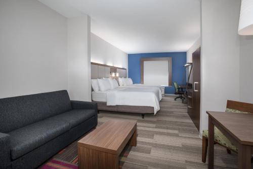 斯莱德尔Holiday Inn Express Slidell, an IHG Hotel的酒店客房,配有床和沙发
