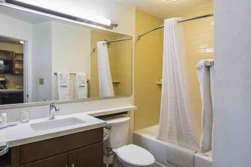 彭萨科拉Candlewood Suites - Pensacola - University Area, an IHG Hotel的一间带水槽、卫生间和镜子的浴室