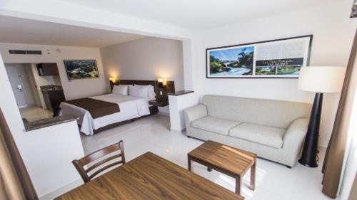 图斯特拉古铁雷斯图斯特拉-古铁雷斯拉马里巴智选假日酒店的酒店客房配有床、沙发和桌子。