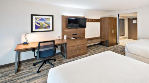 Mount Pleasant普莱森特山快捷假日&套房酒店的酒店客房配有书桌和床。