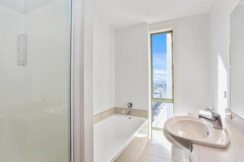 基督城Apartment in the heart of the city的白色的浴室设有浴缸、水槽和浴缸。
