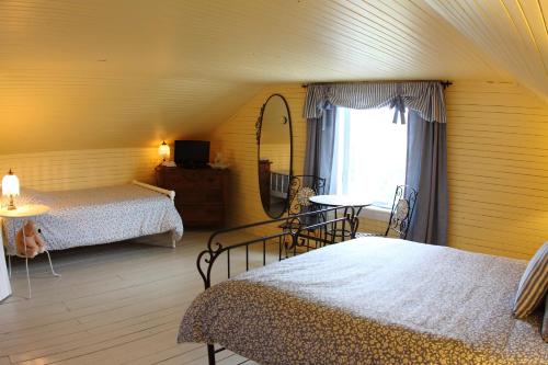 拉拜拉格安奥赫布吉特恩餐厅及酒店住宿的一间卧室设有两张床、镜子和窗户