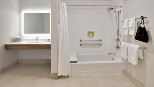 育空俄克拉荷马城西育空快捷假日&套房酒店的带淋浴和盥洗盆的白色浴室