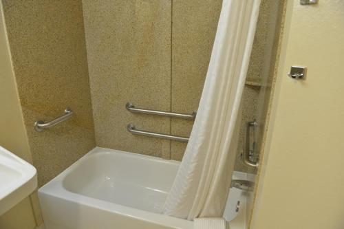 墨尔本Candlewood Suites Melbourne/Viera, an IHG Hotel的带浴缸和淋浴帘的浴室