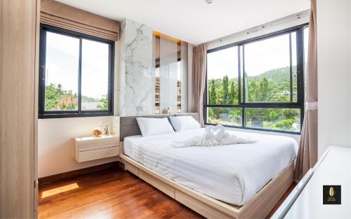 奈汉海滩The Lago Naiharn by Sala Estate的一间卧室配有一张带白色床单和窗户的床。