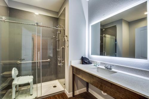 休斯顿Scottish Inns & Suites Houston, TX的一间带玻璃淋浴和水槽的浴室