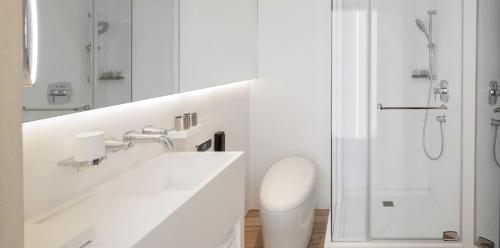 台北二十轮旅店大安馆的白色的浴室设有水槽和淋浴。
