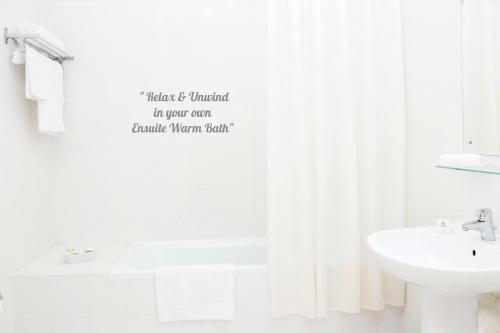 麦纳麦特罗比康纳酒店的白色的浴室设有水槽和淋浴帘