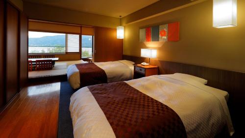 宫岛Aki Grand Hotel & Spa的酒店客房设有两张床和窗户。