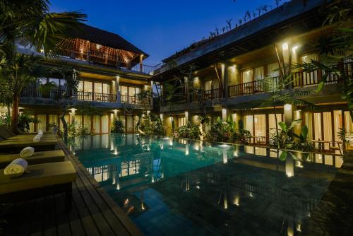 乌布Purana Suite Ubud的夜间设有游泳池的酒店