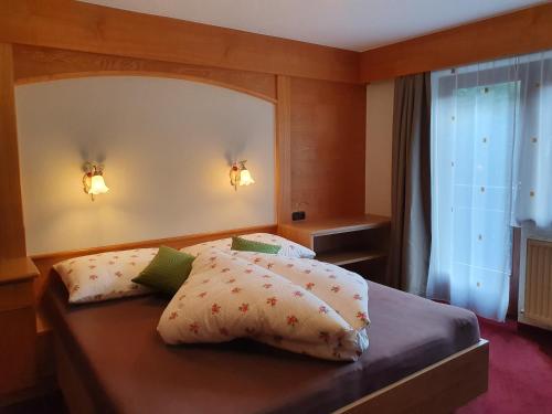 胡本Appartements Karlinger的一间卧室配有带两个枕头的床和窗户