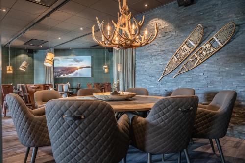 Bredsel大急流酒店的一间带桌椅和吊灯的用餐室