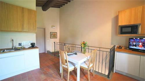 卡尔米尼亚诺podere Sanlorenzo的厨房配有白色的桌椅